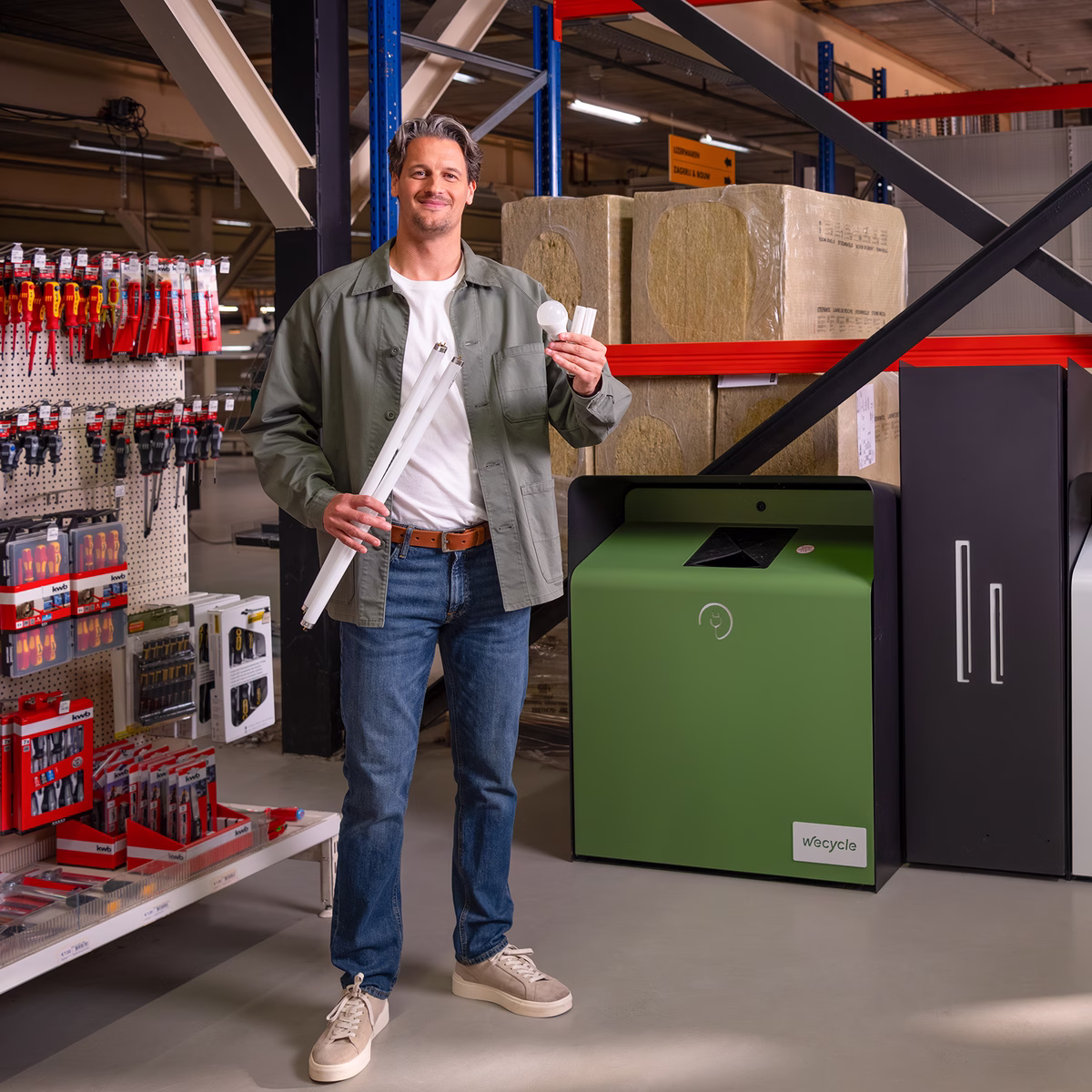Man in bouwwinkel die zijn oude lampen inlevert voor recycling